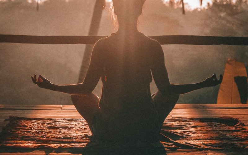 woman doing yoga meditation on brown parquet flooring